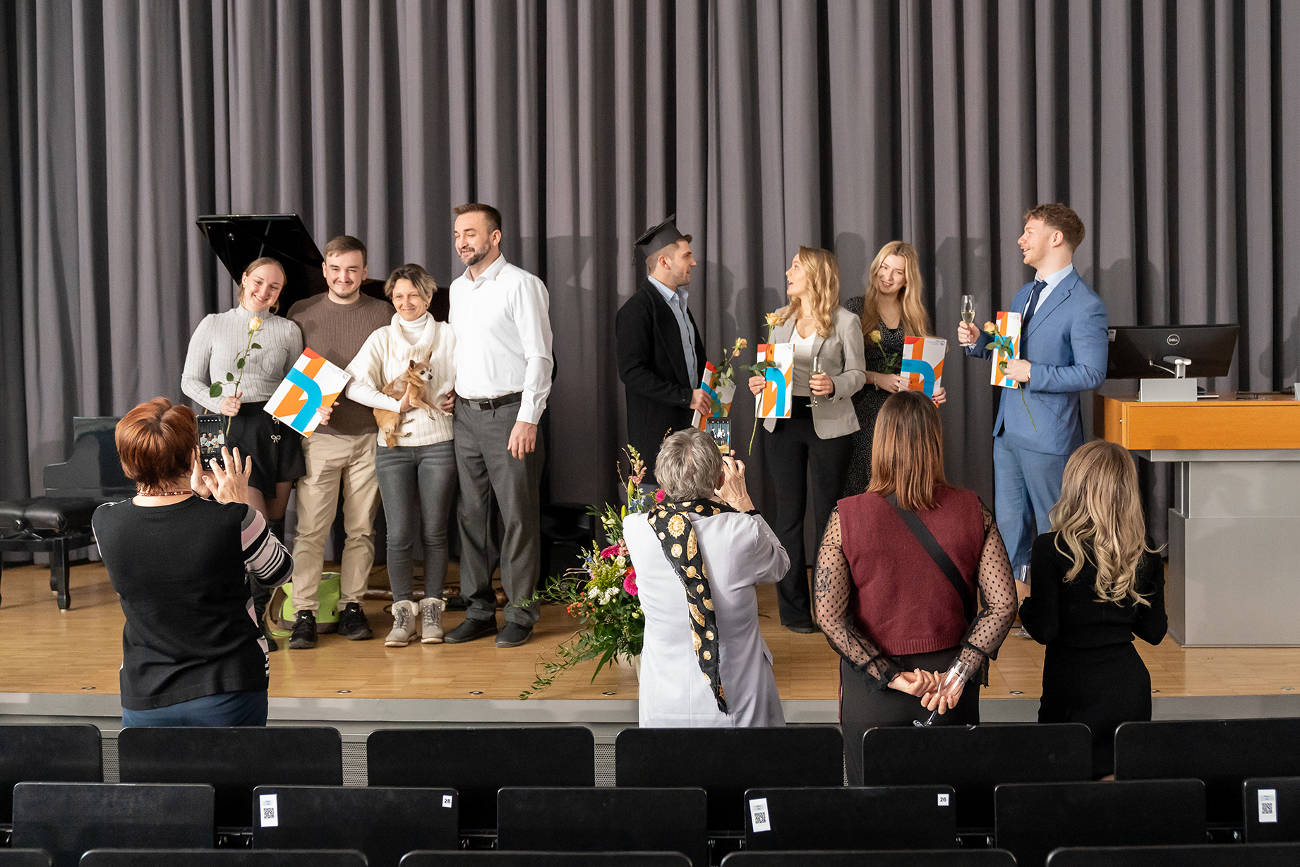 Die Absolvent*innen lassen sich zusammen mit ihren Urkunden fotografieren