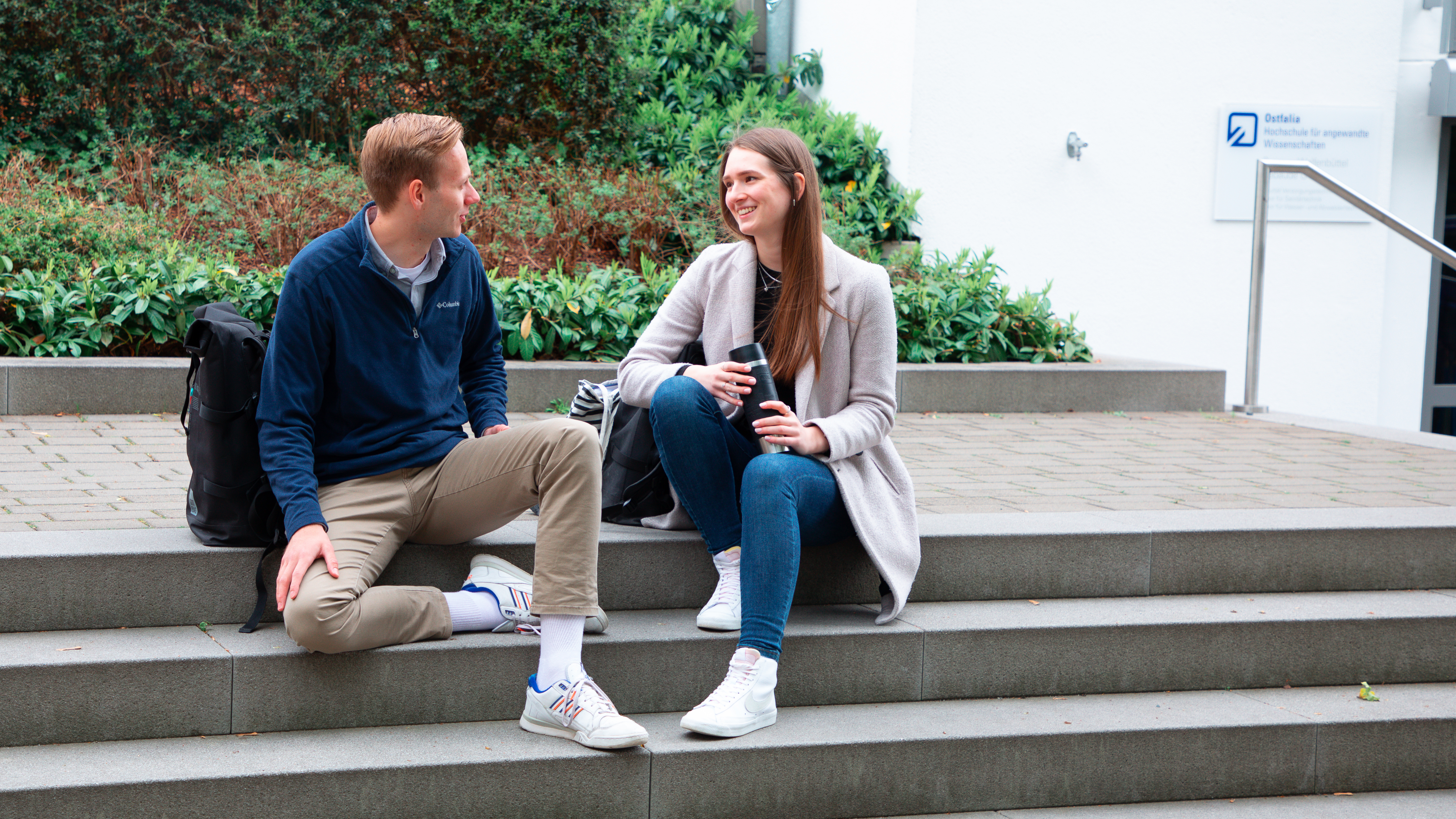 Zwei Studierende sitzend auf einer Treppe